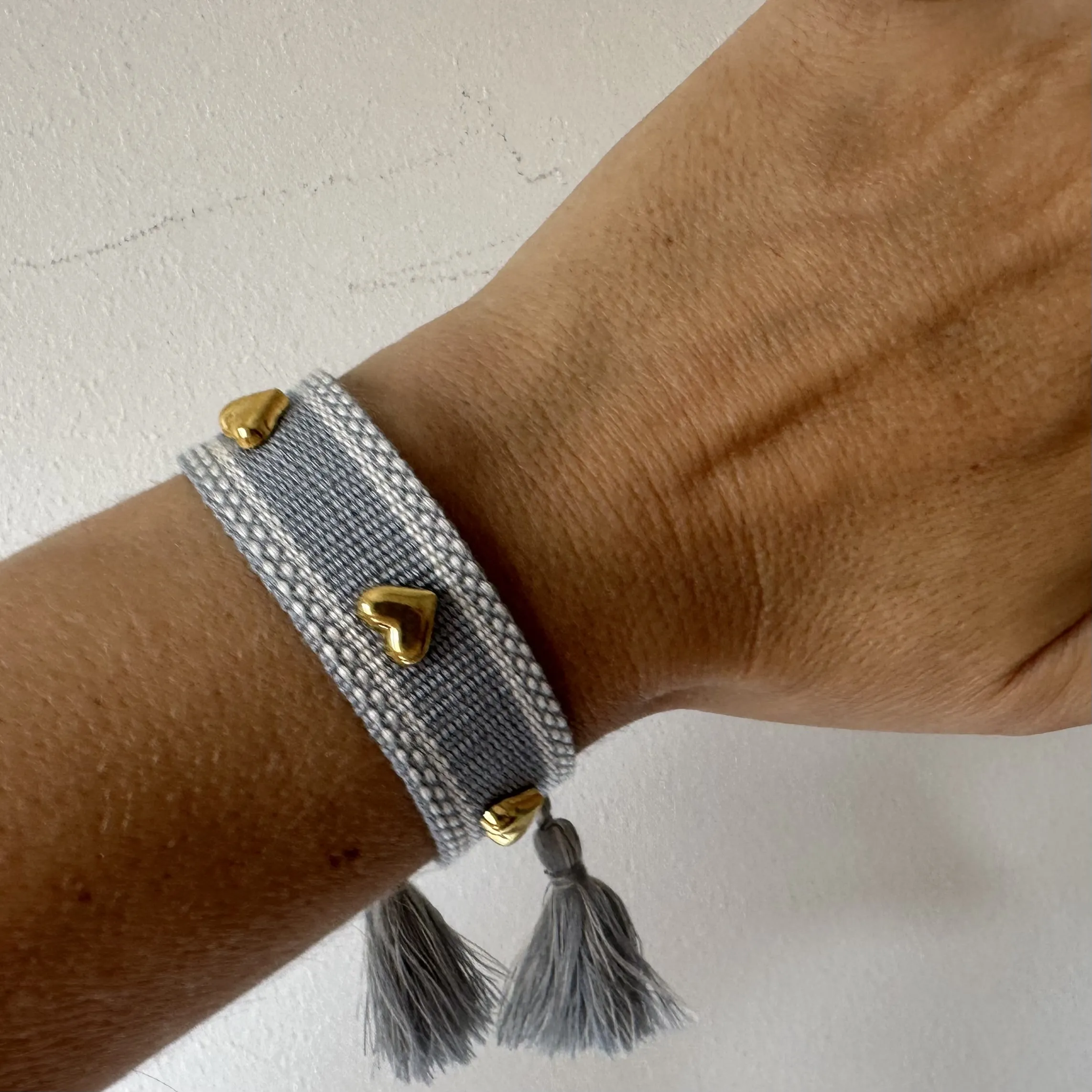 Bracciale in tessuto e borchiette a cuore